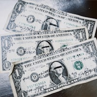 three us dollar bills with writing on them